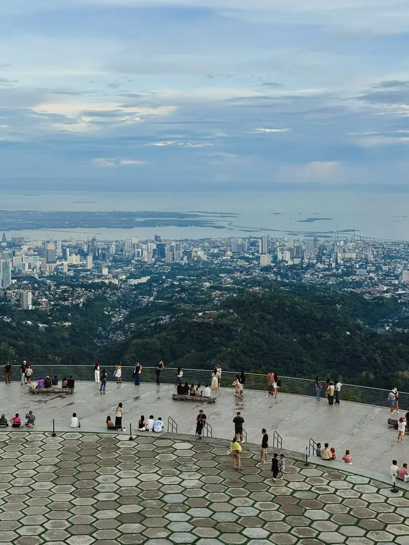 Visitors on the circular terrace of Tops Lookout with Cebu City and the sea in the distance