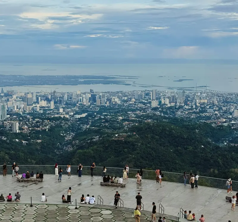 Visitors on the circular terrace of Tops Lookout with Cebu City and the sea in the distance